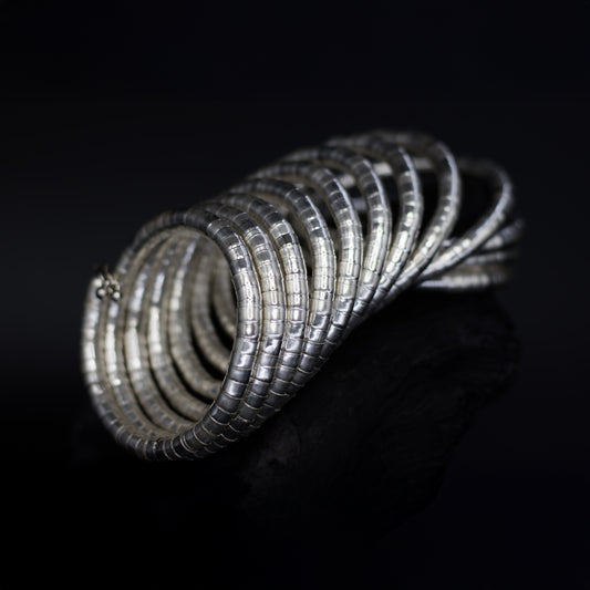 DIVAMAS Silver coil-style spring bangles stacked in side view, contemporary jewelry design for women._02