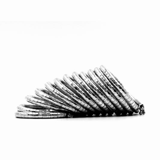 DIVAMAS Silver coil-style spring bangles stacked in side view, contemporary jewelry design for women._07