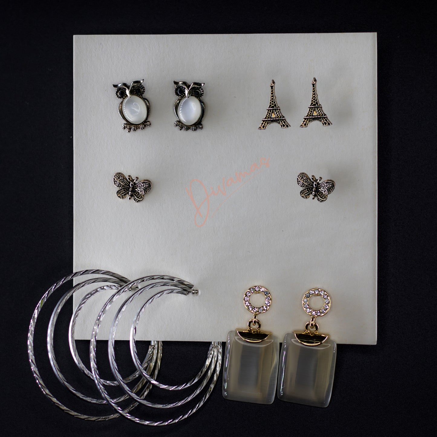 DIVAMAS Women’s Earring Combo featuring Owl Set, Eiffel Tower Set, Butterfly Set, Layered Hoop Set, and Crystal Set; stylish and versatile designs for all occasions.
