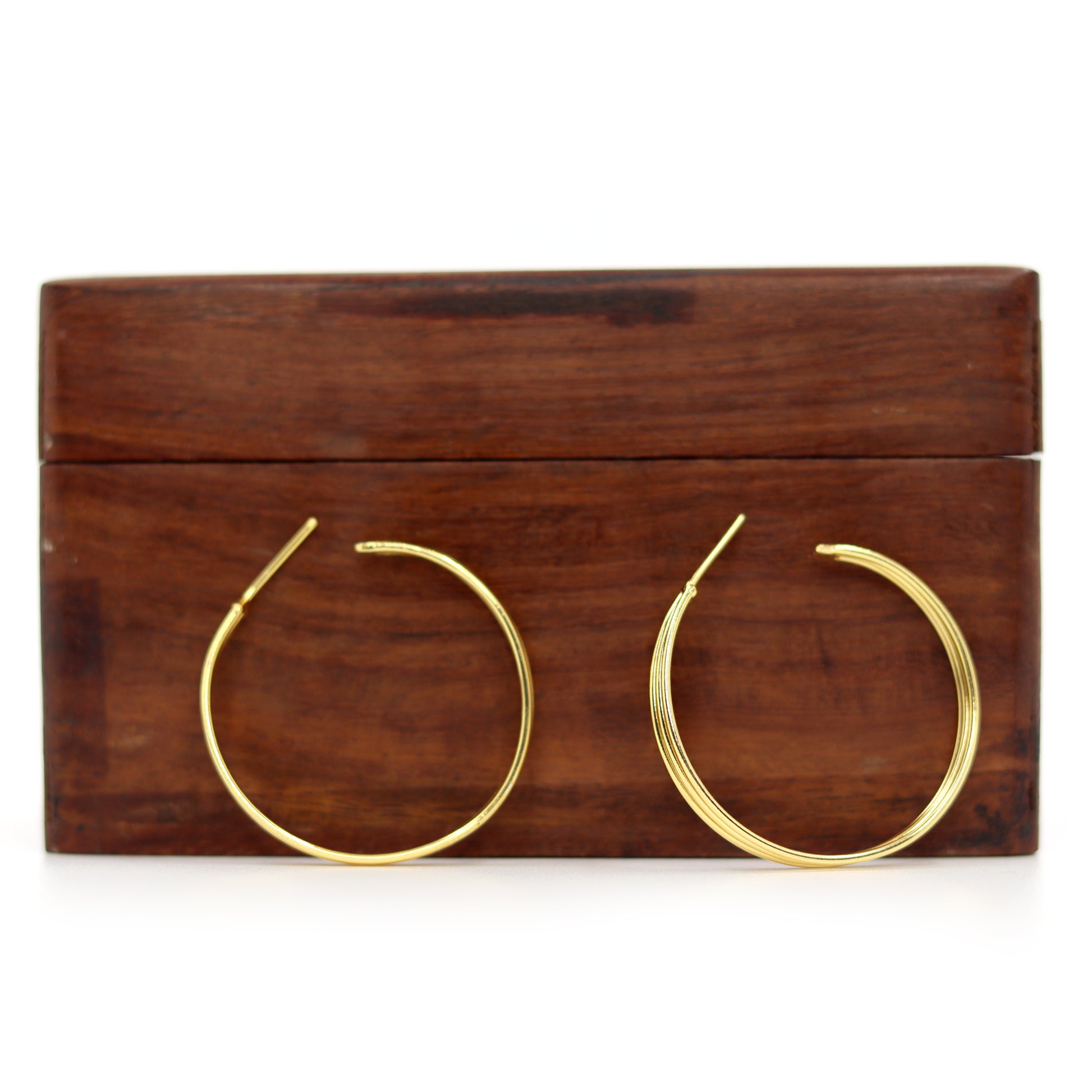 Gold hoop earrings with a sleek, polished finish from DIVAMAS displayed on a white background_03

