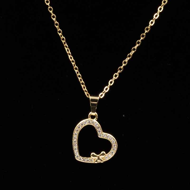 Elegant gold and silver heart pendant necklace featuring an open heart design with sparkling stones and a delicate bow accent, perfect for special occasions and everyday wear.